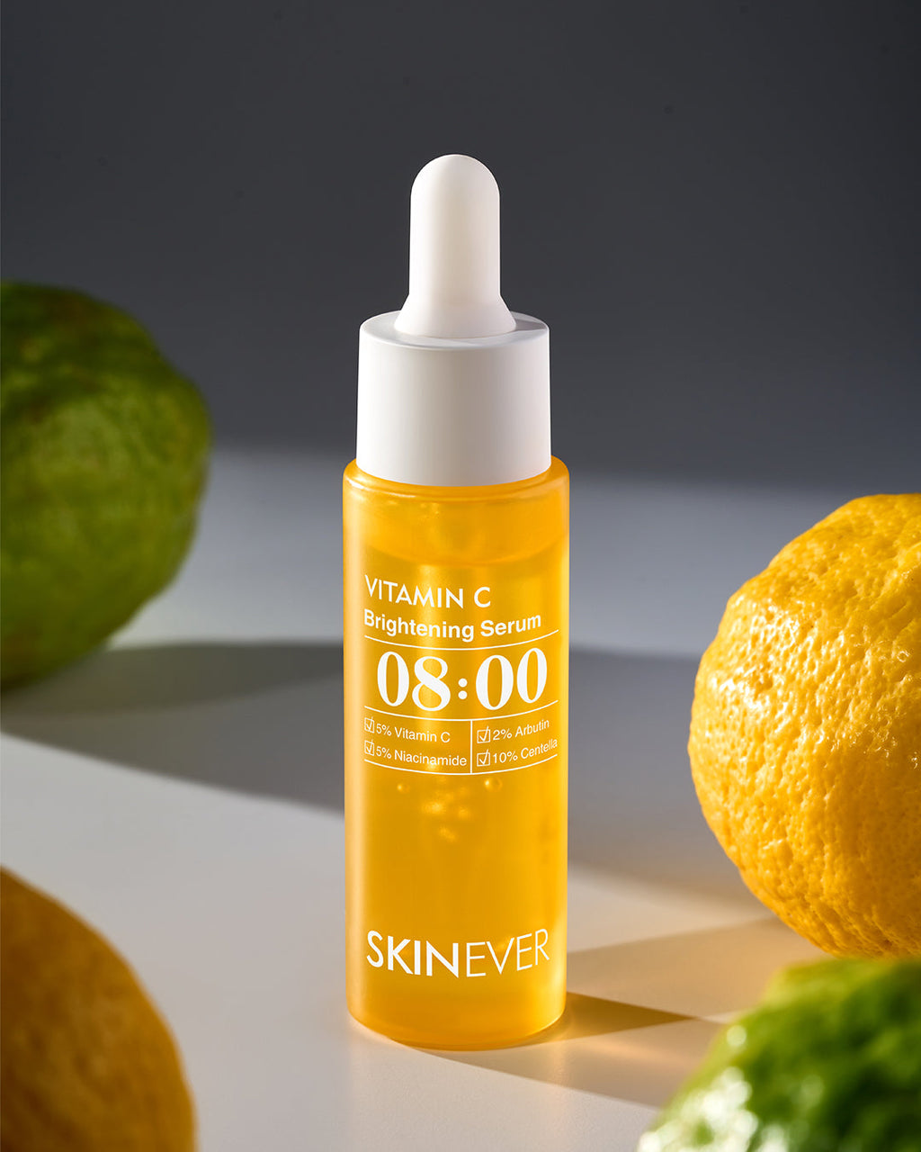 Vitamin C brightening serum bottle with dropper on a neutral background