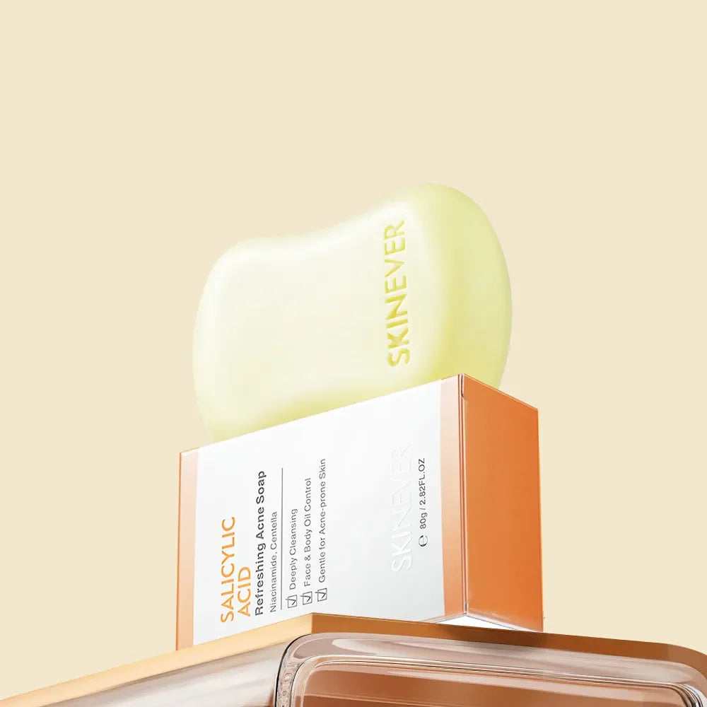 A pale yellow-green bar of SKINEVER Salicylic Refreshing Acne Soap resting on top of its orange and white retail box, set against a solid light beige background.