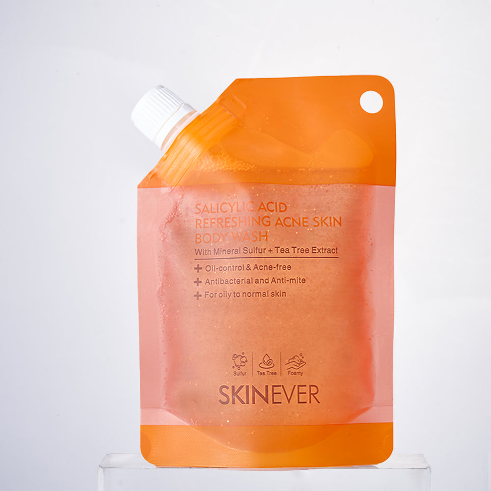 SKINEVER Salicylic Acid Refreshing Acne Skin Body Wash in an orange squeeze pouch with a white cap, displayed on a clear acrylic stand against a light gray background.
