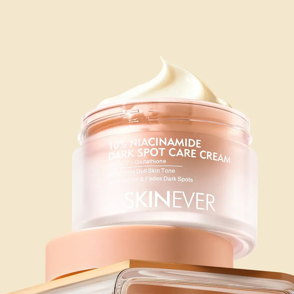 SKINEVER 10% Niacinamide Dark Spot Care Cream in a frosted glass jar with a peach-colored lid, topped with a swirl of white cream, set against a solid pale beige background.