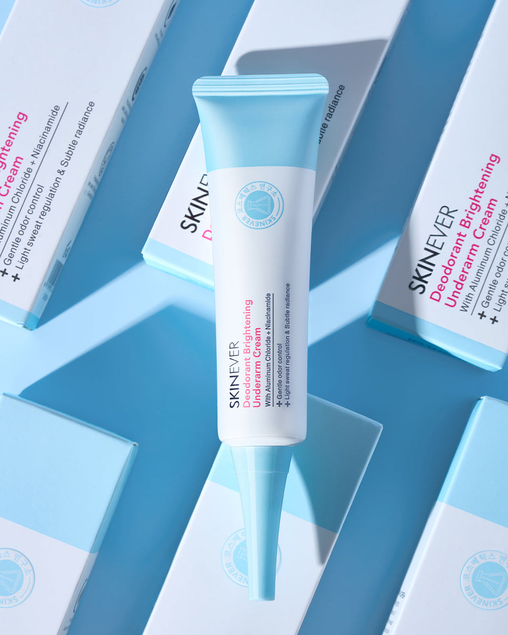 A tube of SKINEVER Decodent Brightening Unleashed Cream stands upright in the center, surrounded by multiple light blue and white product boxes arranged diagonally on a blue background.